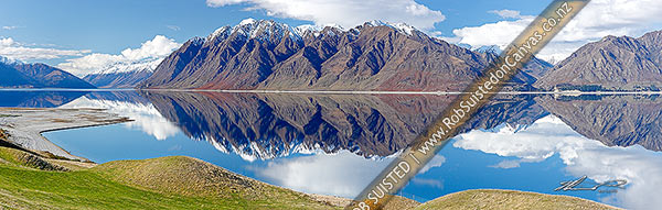 Photo of Lake Hawea on a perfect calm spring/winter day reflecting the surrounding snowy ranges. Panorama, Hawea, Queenstown Lakes, Otago Region, New Zealand (NZ)