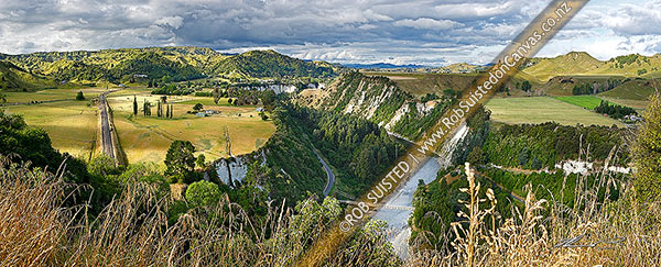 Photo of Mangaweka township visible beyond farmland and white siltstone cliffs above the Rangitikei River. North Island main trunk line left. Panorama, Mangaweka, Rangitikei, Manawatu-Wanganui Region, New Zealand (NZ)