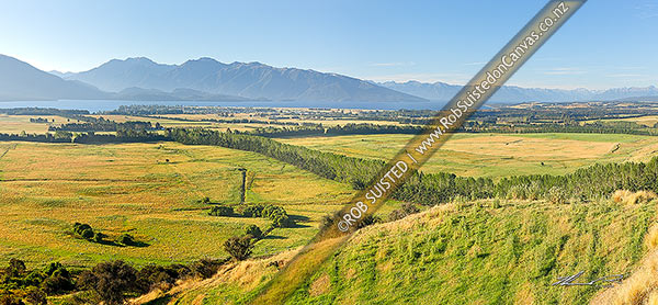 Photo of Farmland with Lake Te Anau and Fiordland mountains and National Park behind. Panorama, Te Anau, Southland, Southland Region, New Zealand (NZ)
