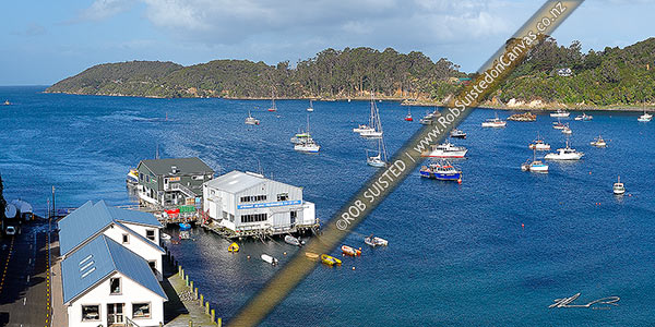 Photo of Halfmoon Bay, wharf, and fishing boats moored in the bay at the main town on Stewart Island, Rakiura. Ackers Point distant, Halfmoon Bay (Oban), Stewart Island, Southland Region, New Zealand (NZ)