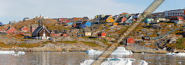 Photo of Ilulissat township seen from the sea, with Zion's church (1779) prominent in the bay, with bright coloured houses on hills. Panorama, Ilulissat, Greenland, Greenland