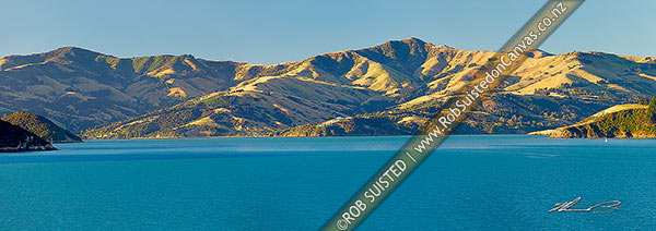 Photo of Akaroa upper harbour with Mt Pearce and Duvauchelle at left, Duvauchelle Peak (738m) and Robinsons Bay centre, and Takamatua with passing sailboat (right) from near Wainui. Banks Peninsula. Panorama, Akaroa, Christchurch City, Canterbury Region, New Zealand (NZ)