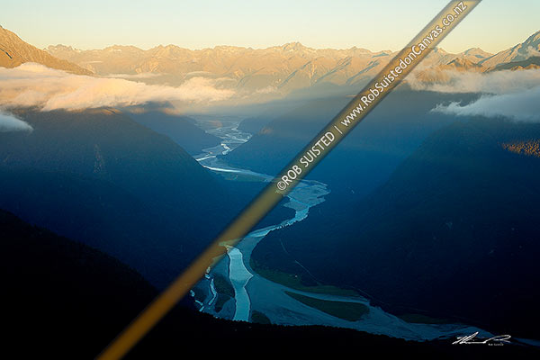 Photo of Haast River Valley below a misty Thomas Range. Southern Alps Range distant. South Westland, Haast, Westland, West Coast Region, New Zealand (NZ)