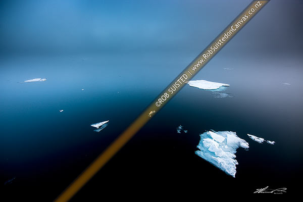 Photo of Sea ice remnants floating on a calm sea amongst fog, Hinelopen Strait (Stretet), Svalbard, Svalbard