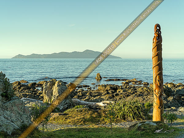 Photo of Pou Tangaroa standing in Pukerua Bay, with Kapiti Island behind (carved Maori pole to the God of the sea), Pukerua Bay, Porirua City, Wellington Region, New Zealand (NZ)