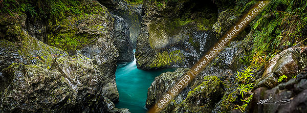 Photo of Tongariro River in rugged water worn basalt rock gorge with moss and ferns. Wide panorama, Kaimanawa Forest Park, Taupo, Waikato Region, New Zealand (NZ)