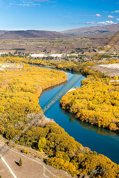 Photo of Clutha River Mata-Au winding through orchards and old gold dredgings. Autumn colours, Alexandra, Central Otago, Otago Region, New Zealand (NZ)