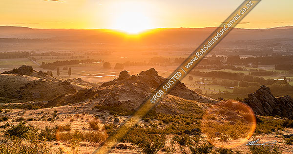 Photo of Earnscleugh sunrise over dry barren hills above Blackmans, with Alexandra and the Clutha (Mata-Au) River plains beyond. Panorama, Alexandra, Central Otago, Otago Region, New Zealand (NZ)