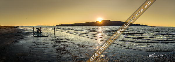 Photo of Kapiti Island sunset with local fishermen clearing a drag net for flounders on Paraparaumu Beach. Panorama, Paraparaumu, Kapiti Coast, Wellington Region, New Zealand (NZ)