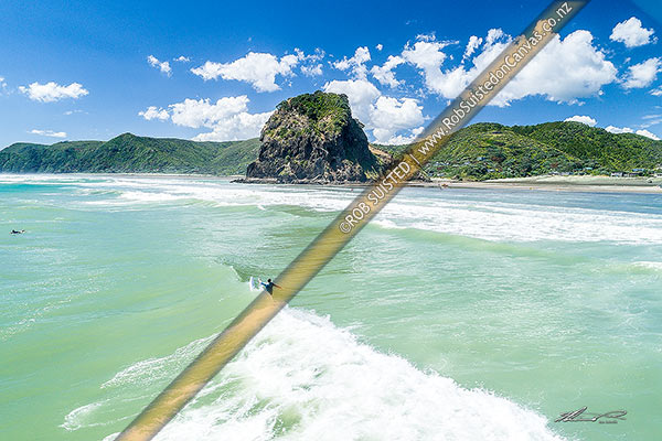 Photo of Piha Beach surfing. Aerial view above surfers catchign waves, with Lion Rock behind. Waitakere Ranges beyond, Whatipu Beach, Waitakere City, Auckland Region, New Zealand (NZ)