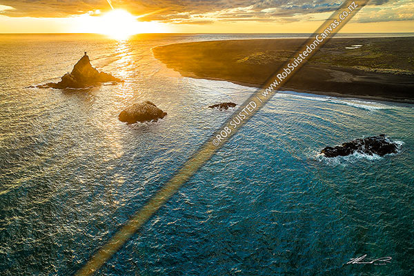 Photo of Whatipu Beach, looking west past Ninepin Rock lighthouse (left). Aerial view at sunset over the black iron rich sand, Whatipu Beach, Waitakere City, Auckland Region, New Zealand (NZ)